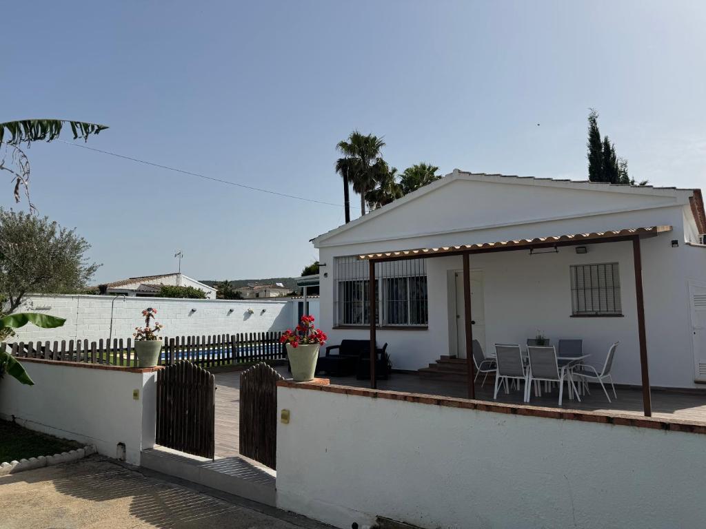 a white house with a deck with a table and chairs at Villa Armonía in Arcos de la Frontera