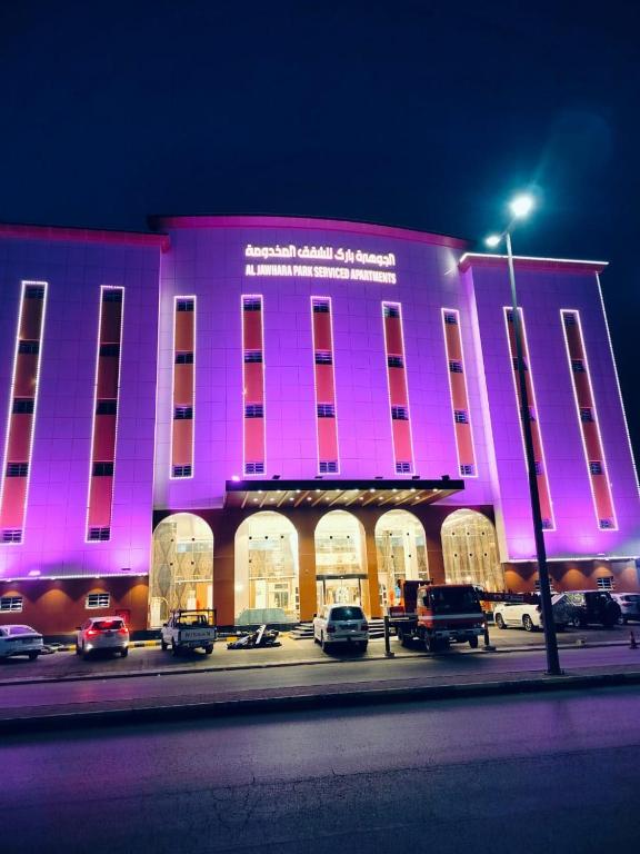 un edificio rosa con coches estacionados frente a él en الجوهرة بارك 4, en Hafr Al Batin