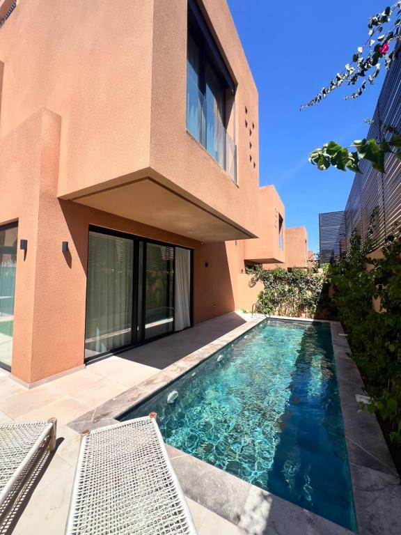 a house with a swimming pool next to a building at Villa Tagana in Marrakesh