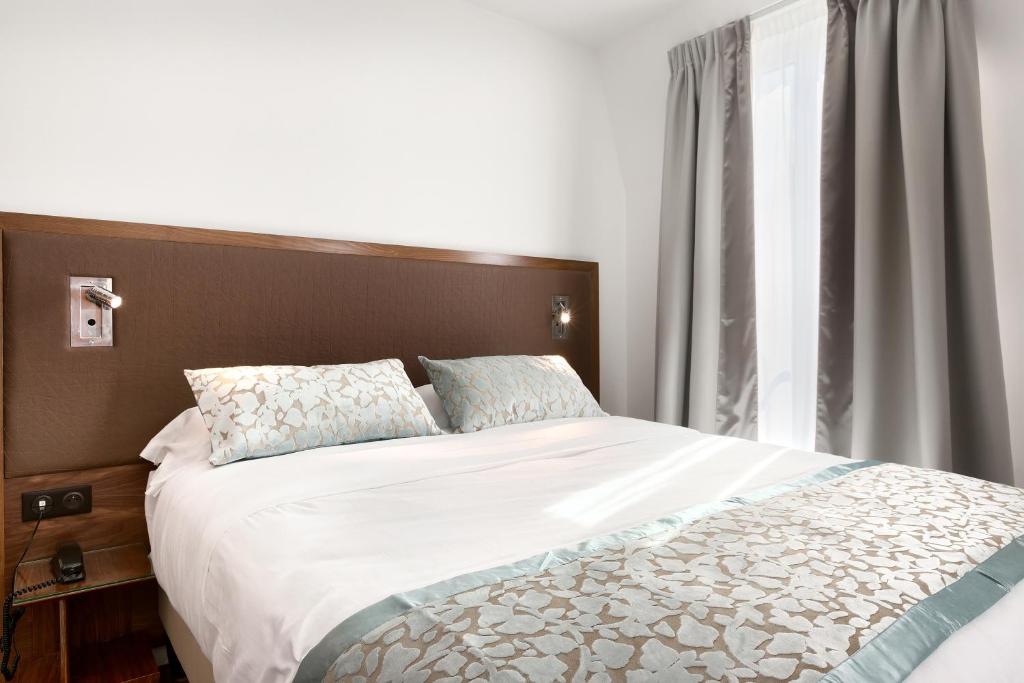 巴黎的住宿－特倫特酒店，一间卧室设有一张大床和一个窗户。