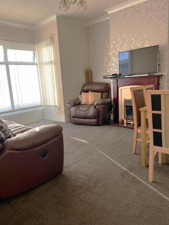 a living room with a couch and a chair and a fireplace at Stylish and Spacious two-bedroom Apartment in Blackpool