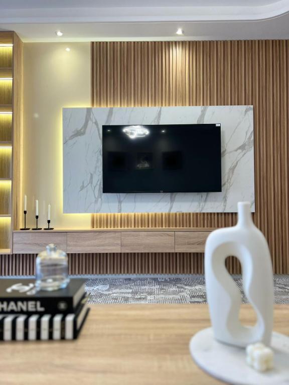 een woonkamer met een tv en een vaas op een tafel bij Lux Rentals 2 chambres - CaboNegro in Cabo Negro