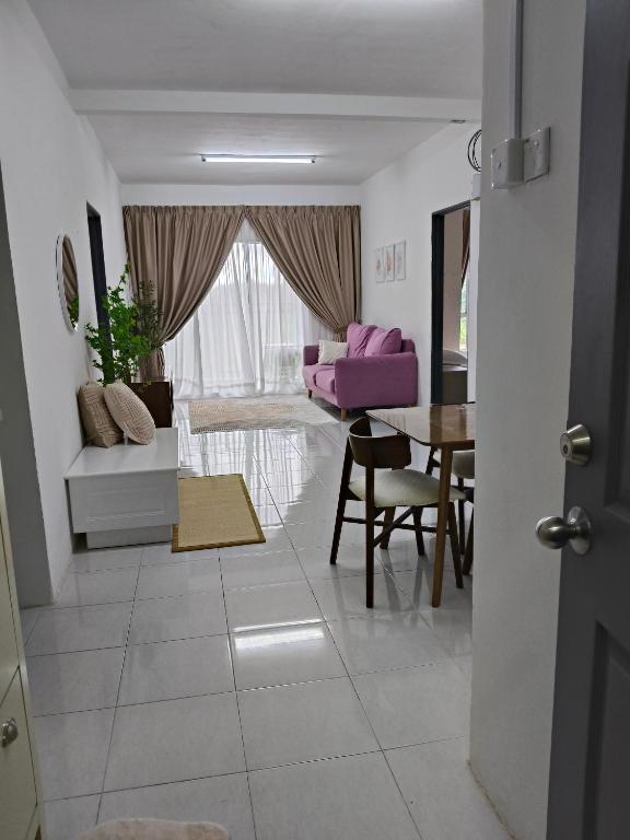 a living room with a purple couch and a table at KhaiLa Emerald Apartment Cameron Highlands in Brinchang