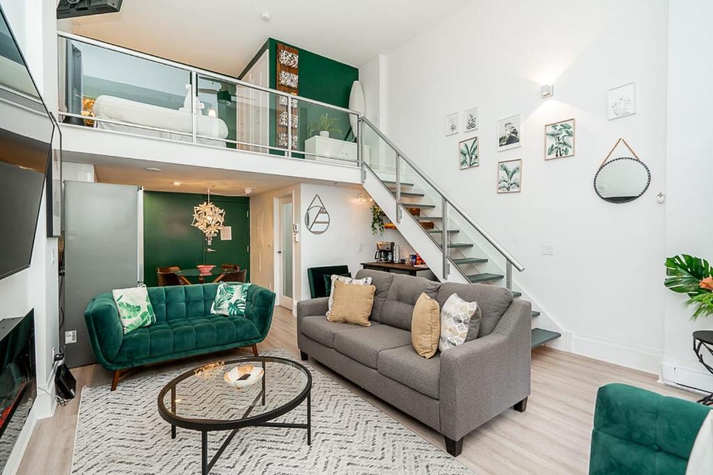 ein Wohnzimmer mit einer Couch und einer Treppe in der Unterkunft Trendy Loft in Downtown in Vancouver