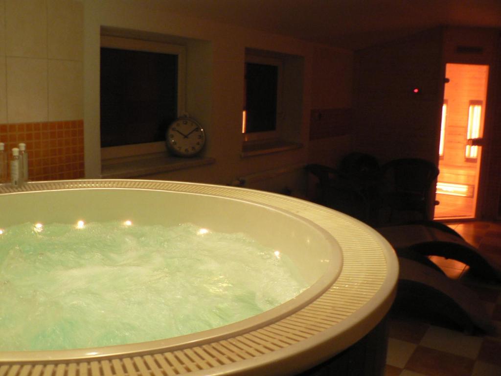 jacuzzi w salonie z zegarem w obiekcie Guest House Pod Hájkem w mieście Horní Branná