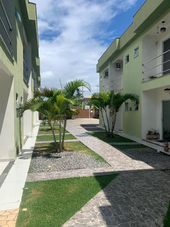a courtyard with palm trees in a building at Residencial Brasil Coroa - Staybeach in Porto Seguro