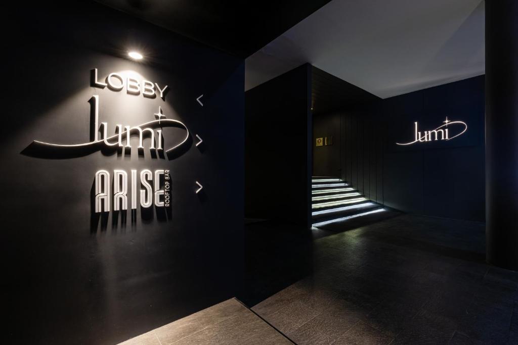 A dark, signposted entrance leads toward the hotel lobby and rooftop venue.