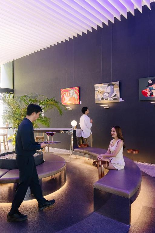 A vivid hotel lounge with sculptural seating, art, and staff service.