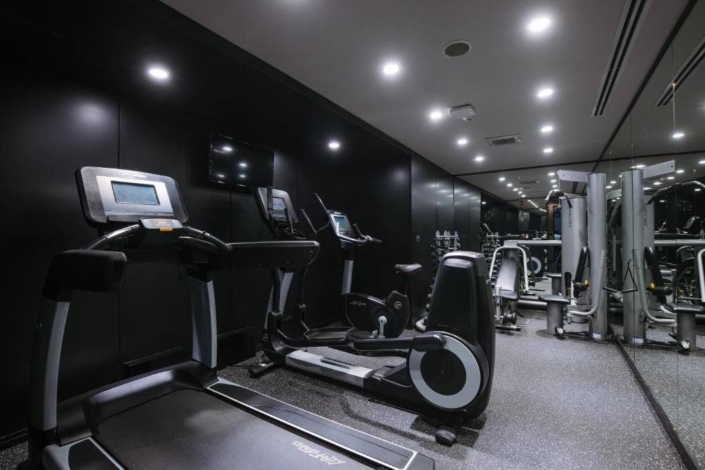 A compact, dark-toned gym with cardio and weight equipment.