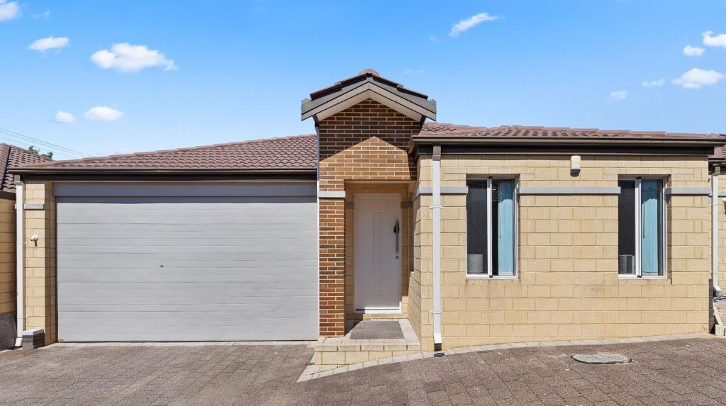 a brick house with a white garage door at 78 Modern Comforts Quiet Charm 3BR 2BA Parking in Perth