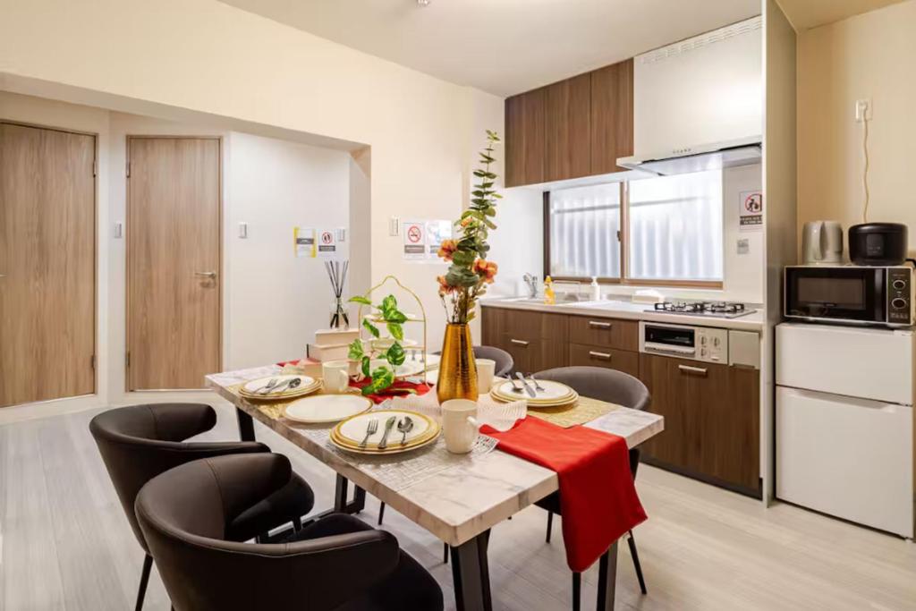 a kitchen with a table and chairs in a room at Residential Hotel GRAN梅香 Newly opened Hotel Baika Family friendly Free parking 10 minutes to USJ in Osaka