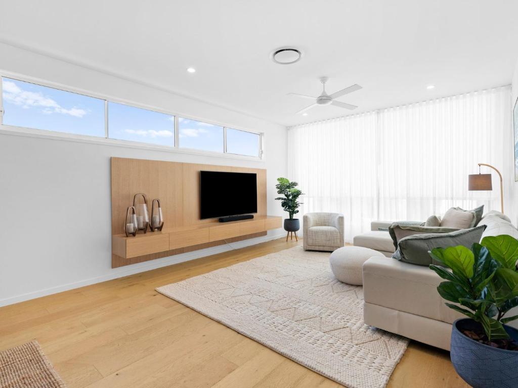 Baja on Cylinders - Beachfront Bliss في كينغسكليف: غرفة معيشة مع أريكة وتلفزيون بشاشة مسطحة