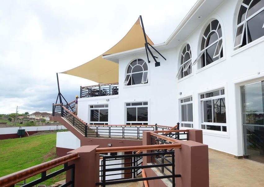 - un bâtiment blanc avec un escalier et un balcon dans l'établissement Greenpark Sundowner, à Athi River