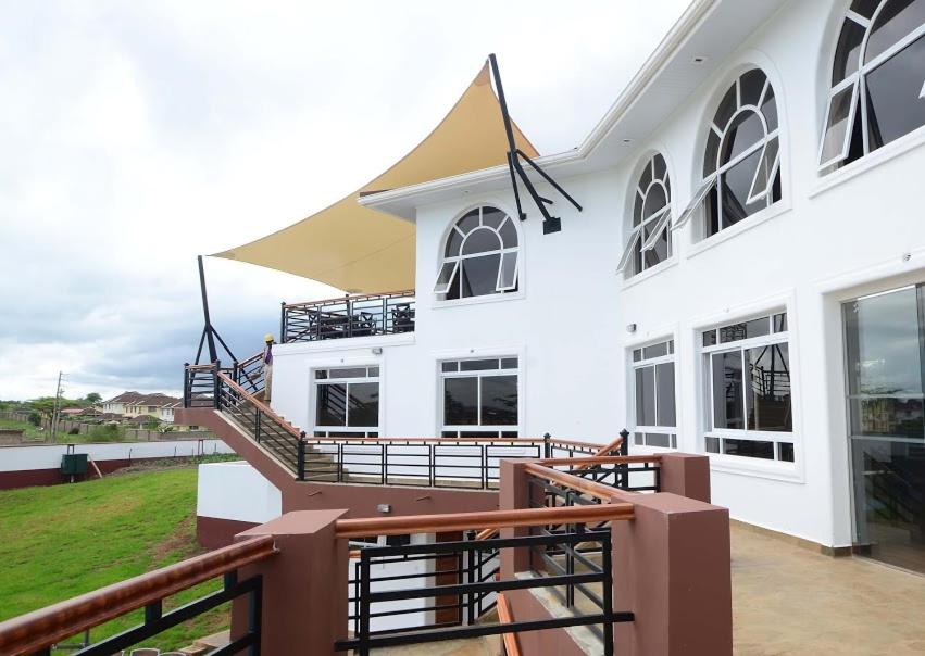 a white building with a staircase and a balcony at Greenpark Sundowner in Athi River