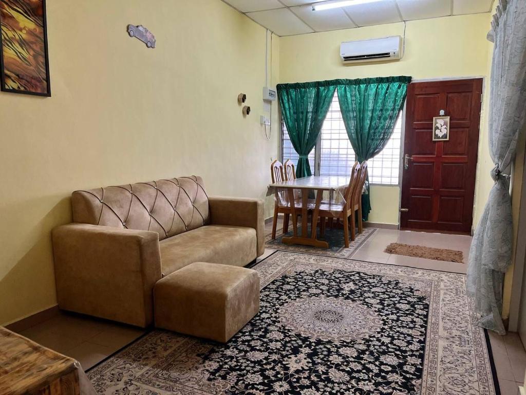a living room with a couch and a table at Hijau Homestay in Batu Gajah