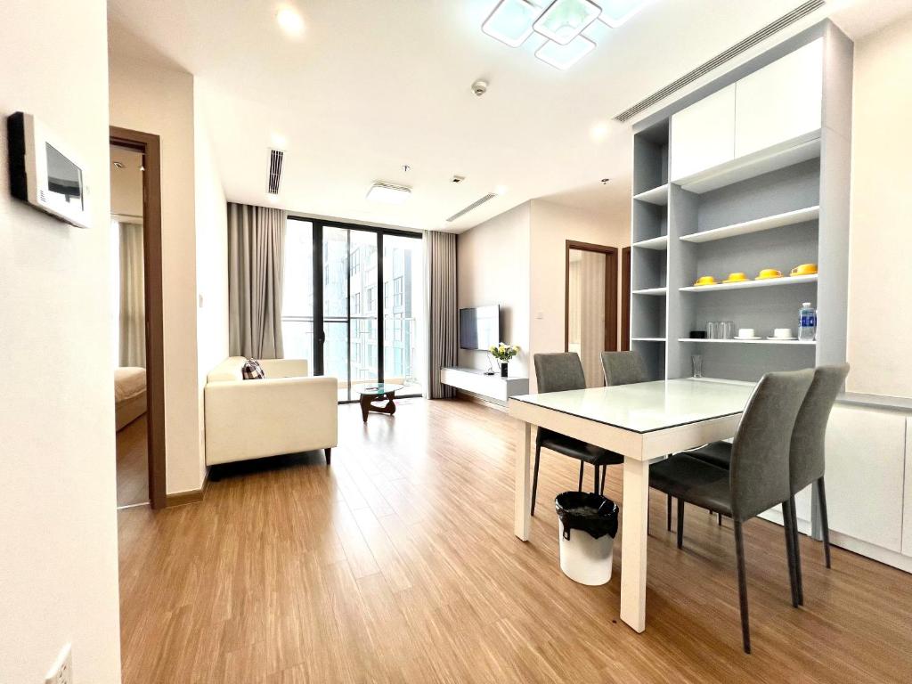 a living room with a dining room table and chairs at Luxury Apartment Vinhomes Skylake in Hanoi