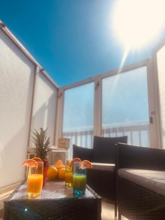 une table avec deux boissons sur une table avec des oranges dans l'établissement Sun and Beach of Palavas, à Palavas-les-Flots