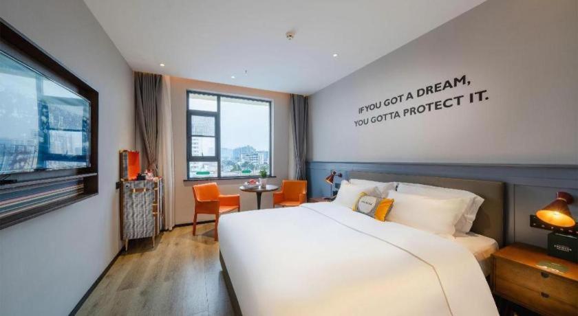 a bedroom with a large white bed and a window at Premier City Comfort Hotel Suizhou Wuyue Plaza in Suizhou
