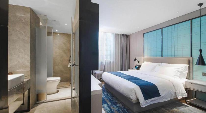 une chambre avec un lit et une salle de bain avec baignoire dans l'établissement Echarm Hotel Changsha Wuyi Square Xiangya Affiliated 1st Provincial Maternity and Child, à Changsha