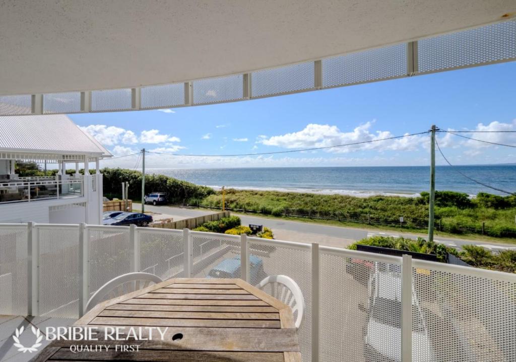 a balcony with a table and a view of the ocean at Above The Dunes in Woorim
