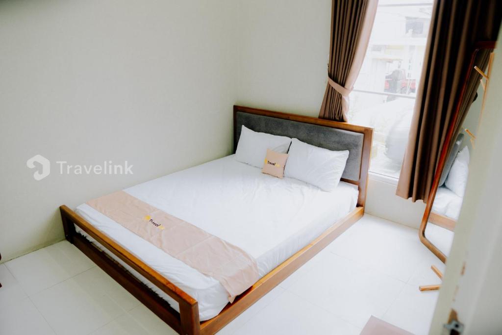 un petit lit dans une chambre avec une fenêtre dans l'établissement Dieng Top Syariah By Travelink, à Diyeng