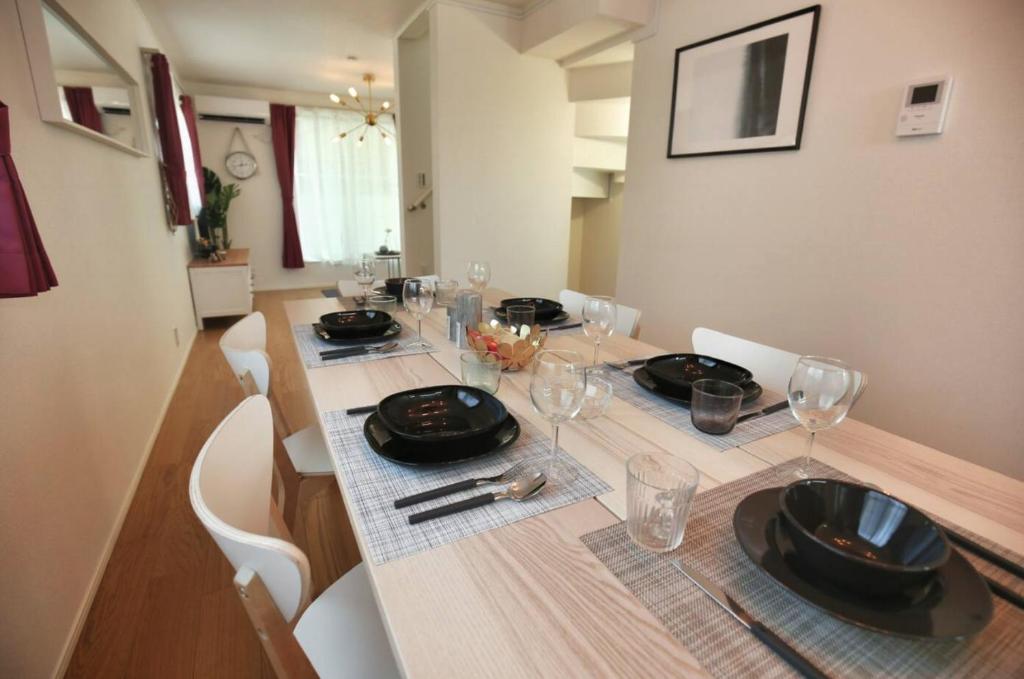 uma mesa de jantar com pratos e copos em SCD155 Spacious Villa in Ikebukuro Suburbs Direct Access to Tokyo's Core Commercial Districts em Tóquio
