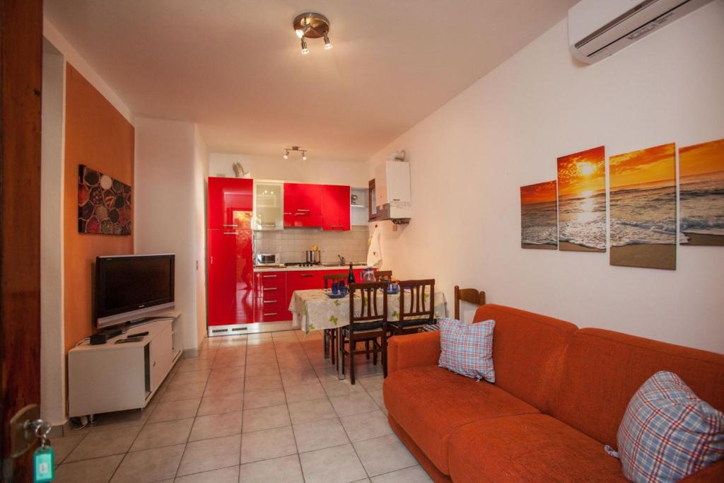 a living room with a couch and a kitchen at Charming 2-room apartment in a peaceful residential area in Rosolina Mare