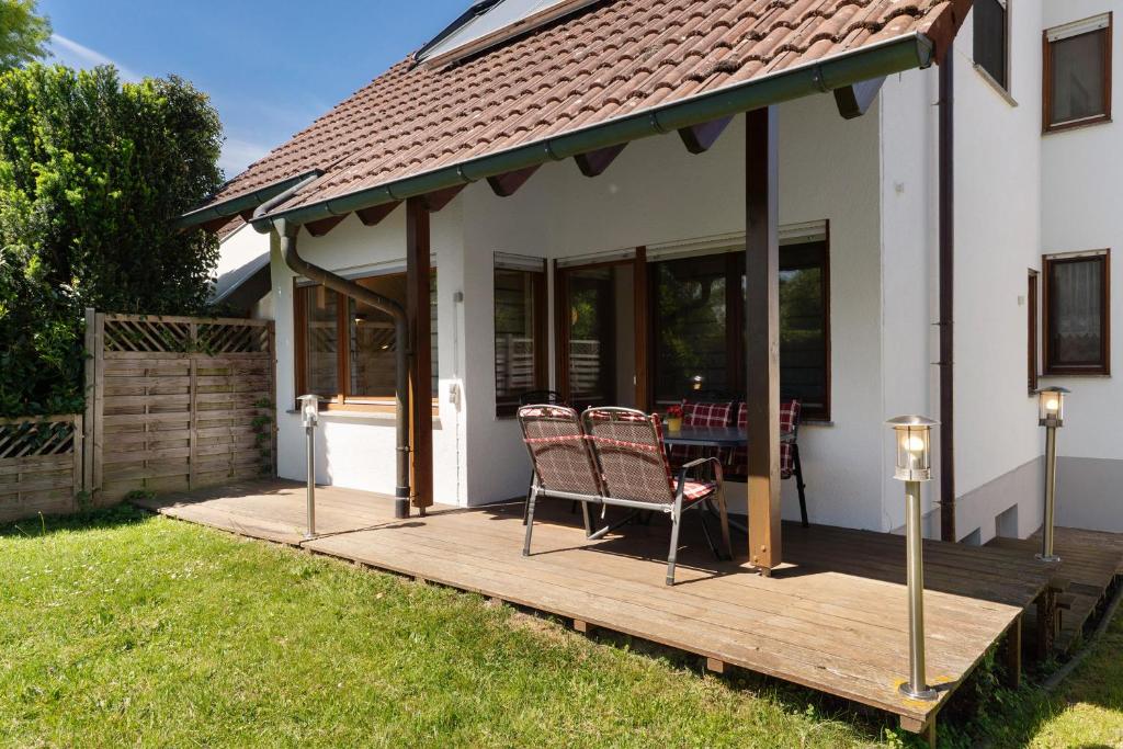 a deck with two chairs and a table on it at Ferienhaus am Mühlenbach, 110qm in Schwanau