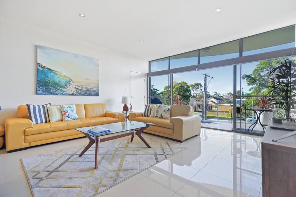 Una sala de estar con dos sofás y una mesa. en Aqua Shores - 1 Bedroom couples stay - Wifi, Linen, Netflix and AC, en Huskisson