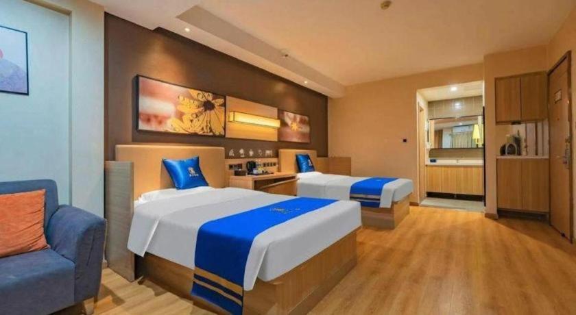 a hotel room with two beds and a couch at IU Hotel Chengdu High-Tech Zone Longhu Times Street in Xipu
