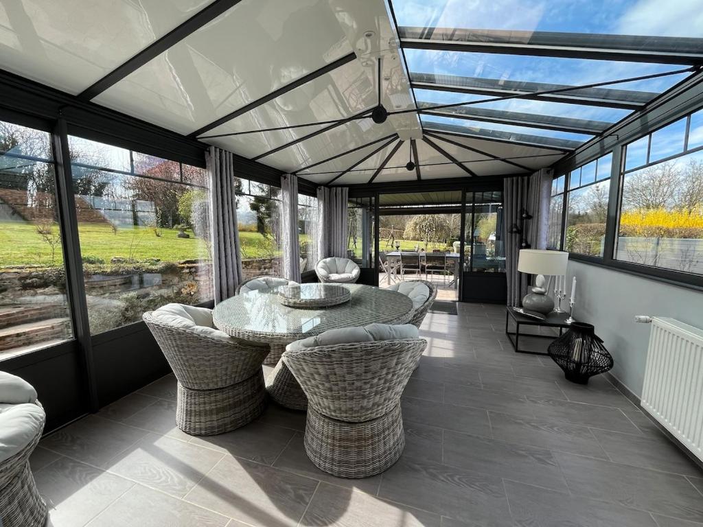 une salle à manger avec une table, des chaises et des fenêtres dans l'établissement Gîte le Pilon, à Verdon