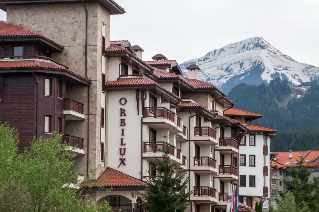 a hotel with a mountain in the background at Apart Hotel Orbilux in Bansko