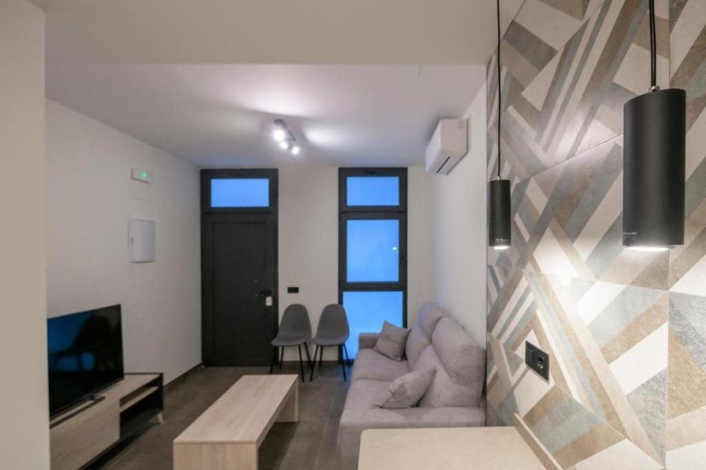 Una sala de estar con un sofá y un televisor. en Céntrico 4 personas Ciudad Ciencias, en Valencia
