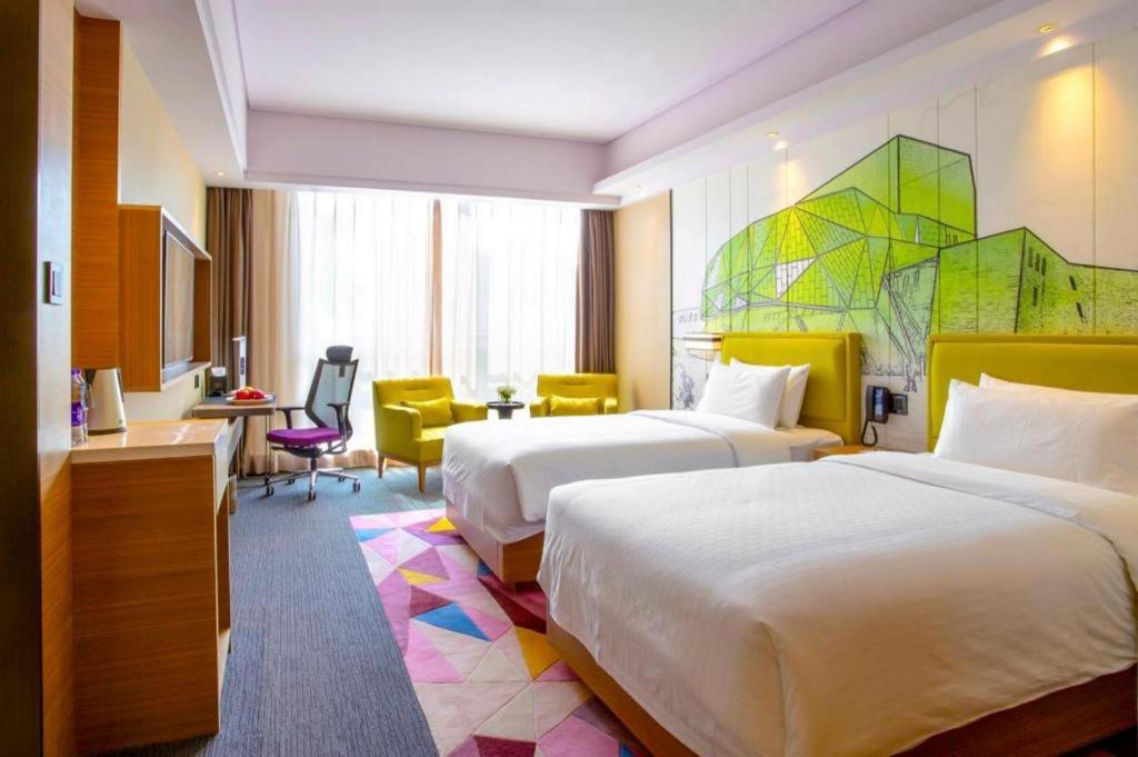 a hotel room with two beds and a desk at Hampton by Hilton Xi'an Dayan Pagoda in Xi'an