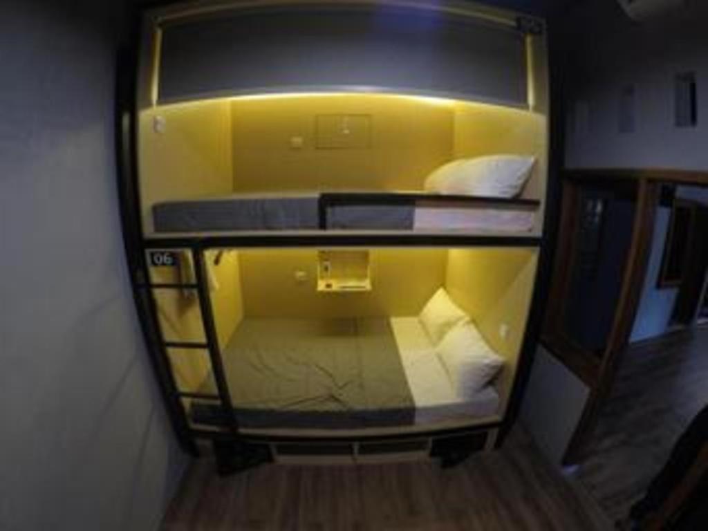 Postel nebo postele na pokoji v ubytování InnBox Capsule Hotel
