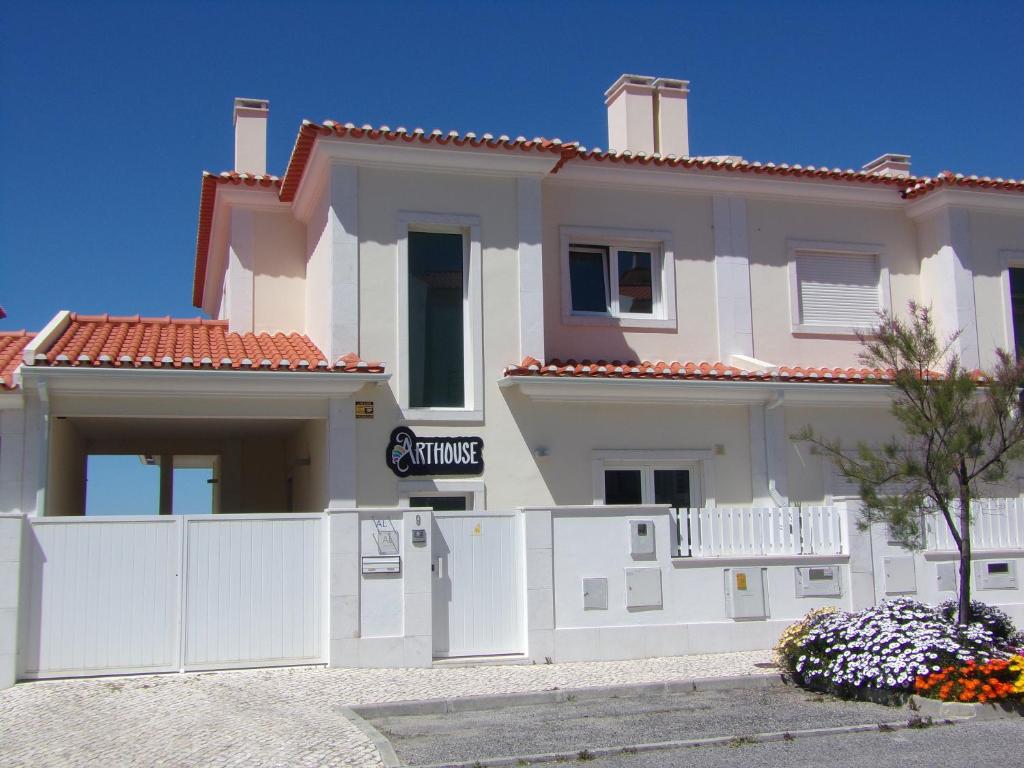 a house with a white fence in front of it at Arthouse Surf Ericeira in Ericeira