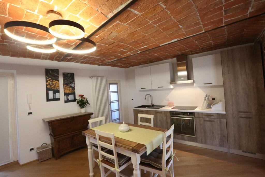 cocina con mesa de comedor y techo en Alba sui Tetti apartment, en Alba