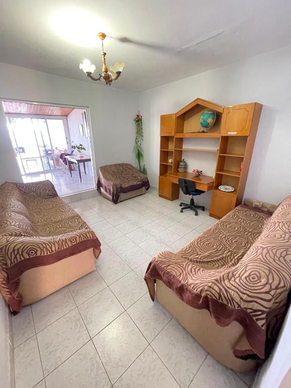 a bedroom with two beds and a desk and a table at Hotel Gjika in Sarandë