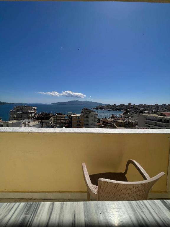 a chair and table on a balcony with a view at Hotel Gjika in Sarandë
