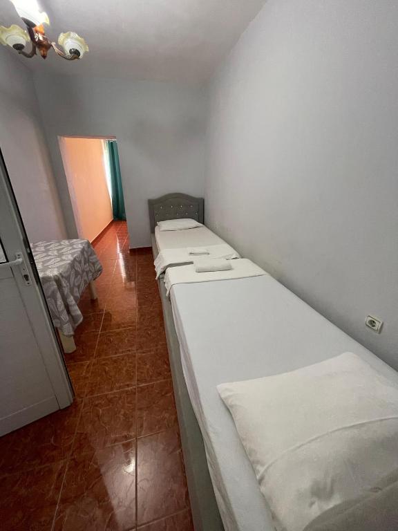a small room with two beds in a room with at Hotel Gjika in Sarandë