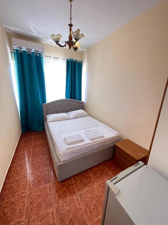 a small bedroom with a bed and a window at Hotel Gjika in Sarandë