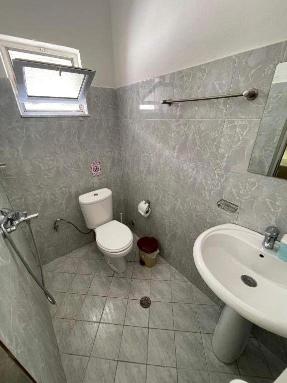 a bathroom with a toilet and a sink at Hotel Gjika in Sarandë