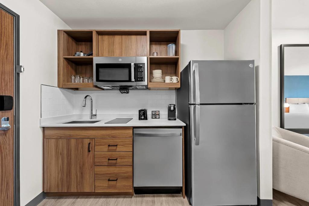 a kitchen with a refrigerator and a microwave at Everhome Suites Brownsville in Brownsville