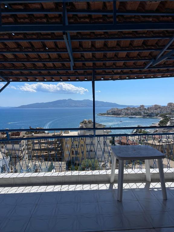a bench sitting on a balcony looking out at the ocean at Hotel Gjika in Sarandë