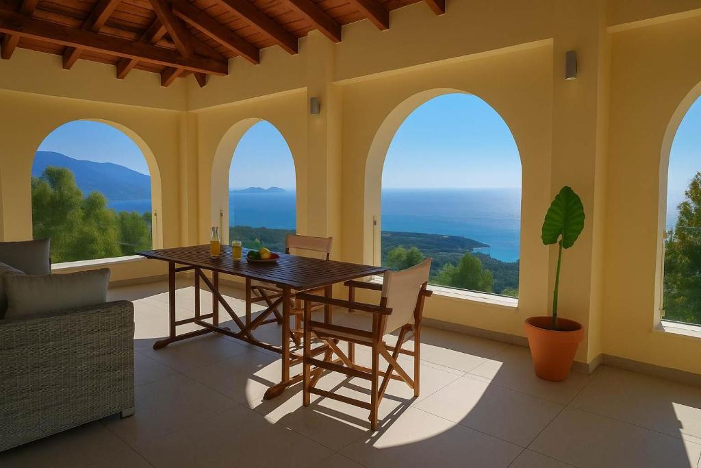 Un comedor con mesa y sillas y ventanas. en Aegean Sea Views-Marathos Retreat Samos, en Kámpos