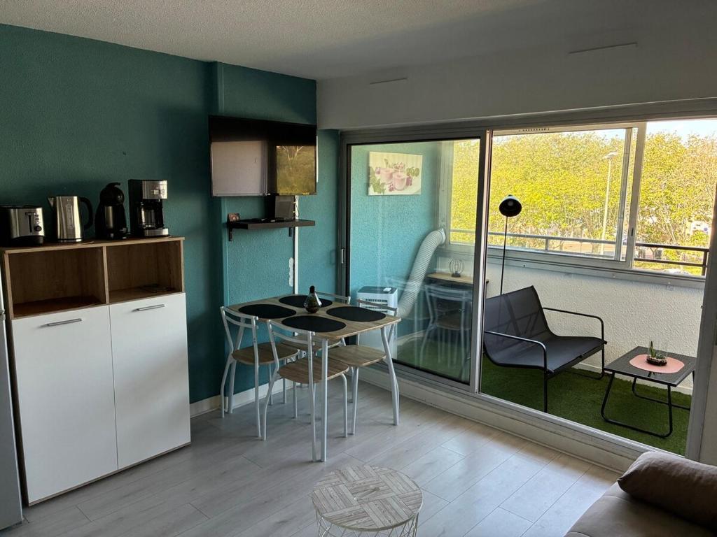 una cucina con un tavolo e sedie in una stanza di Evasion marine, appartement idéalement situé a Cap d'Agde
