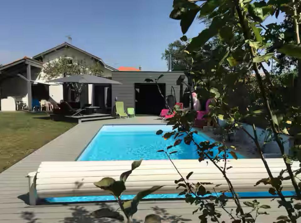 une cour arrière avec une piscine et une maison dans l'établissement Villa spacieuse piscine jardin jacuzzi, à La Celle-sous-Gouzon