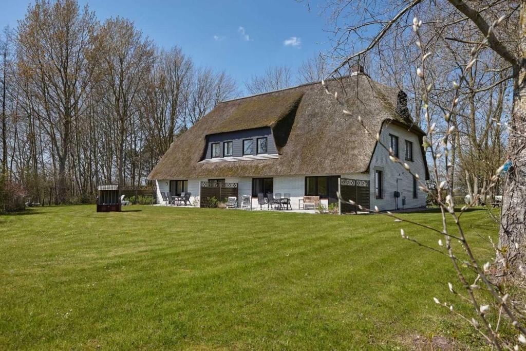 una gran casa blanca con techo de paja en Wohnung 4 Seerobbe ID 441, en Vollerwiek