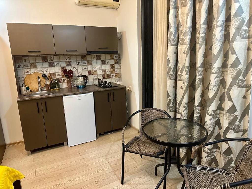 a small kitchen with a table and a table and chairs at cosy house in Kobuleti