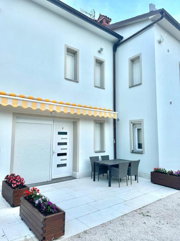 a patio with a table and chairs in front of a building at Apartments ENA near Rovinj in Šorići